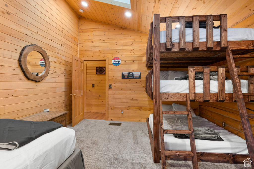Carpeted bedroom with wooden walls, wooden ceiling, vaulted ceiling, and recessed lighting