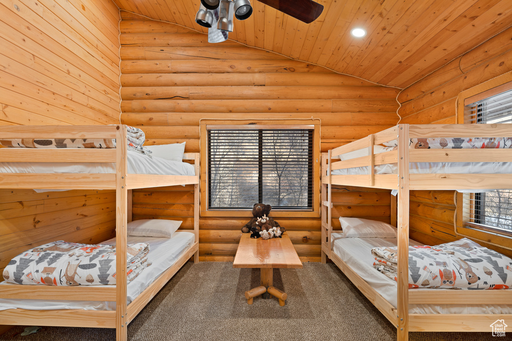 Bedroom with log walls, wooden ceiling, and lofted ceiling
