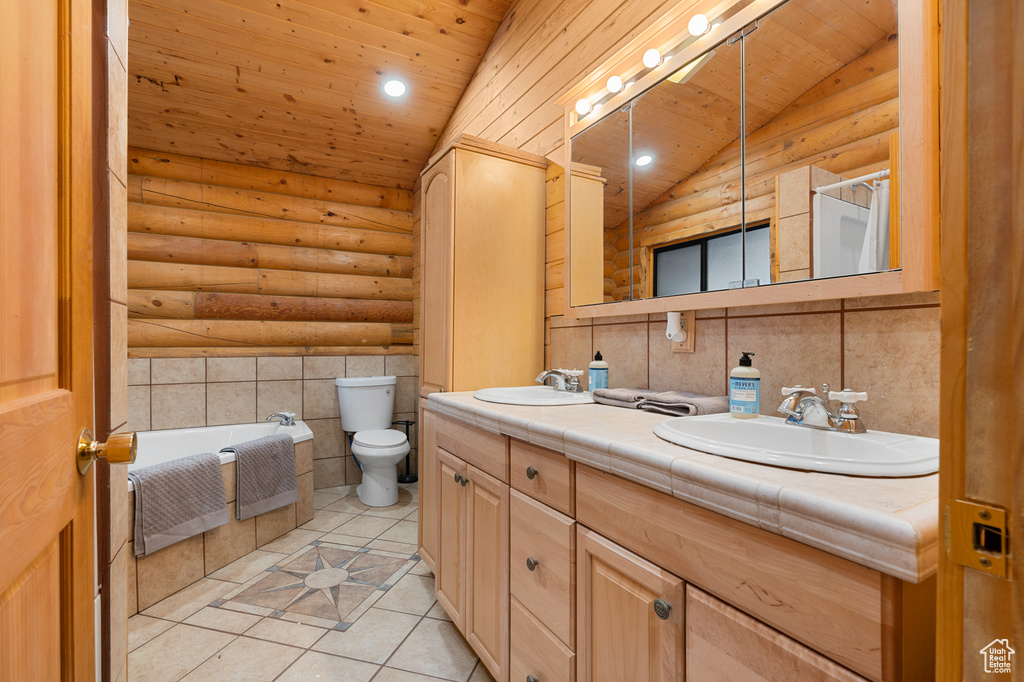 Bathroom featuring tile patterned flooring, wooden ceiling, toilet, double vanity, and a bath