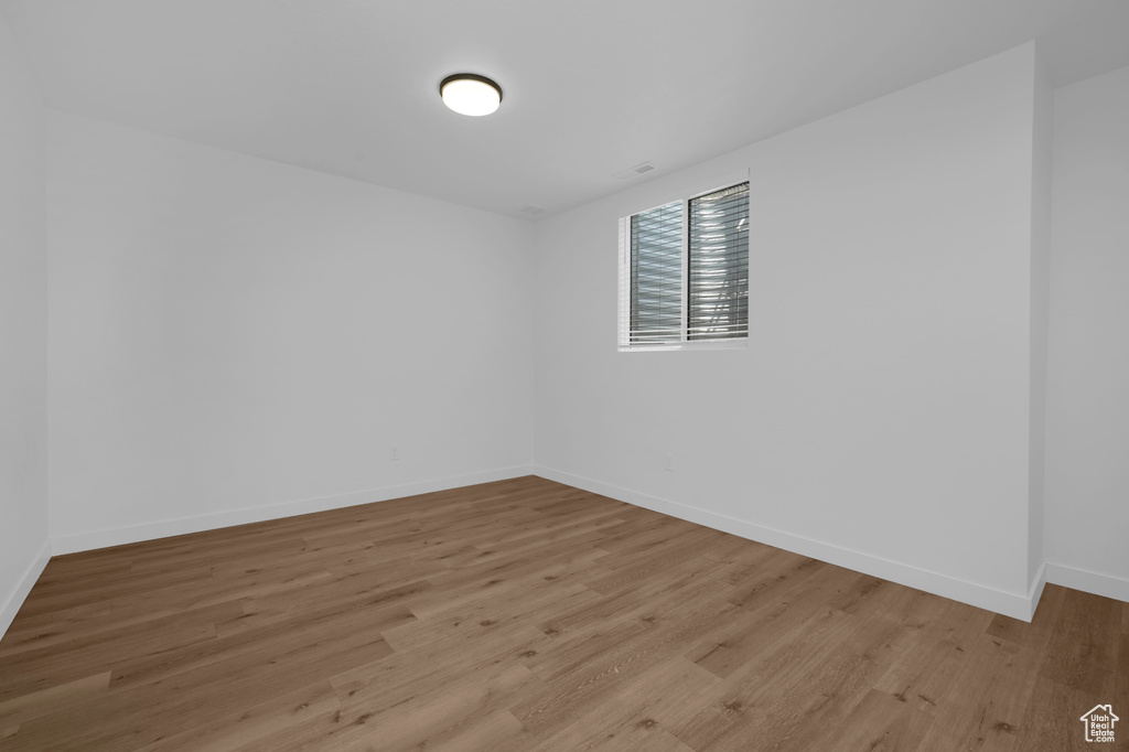 Unfurnished room with light wood-style flooring and baseboards