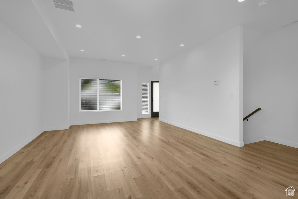 Unfurnished living room featuring recessed lighting, light wood-style flooring, and baseboards
