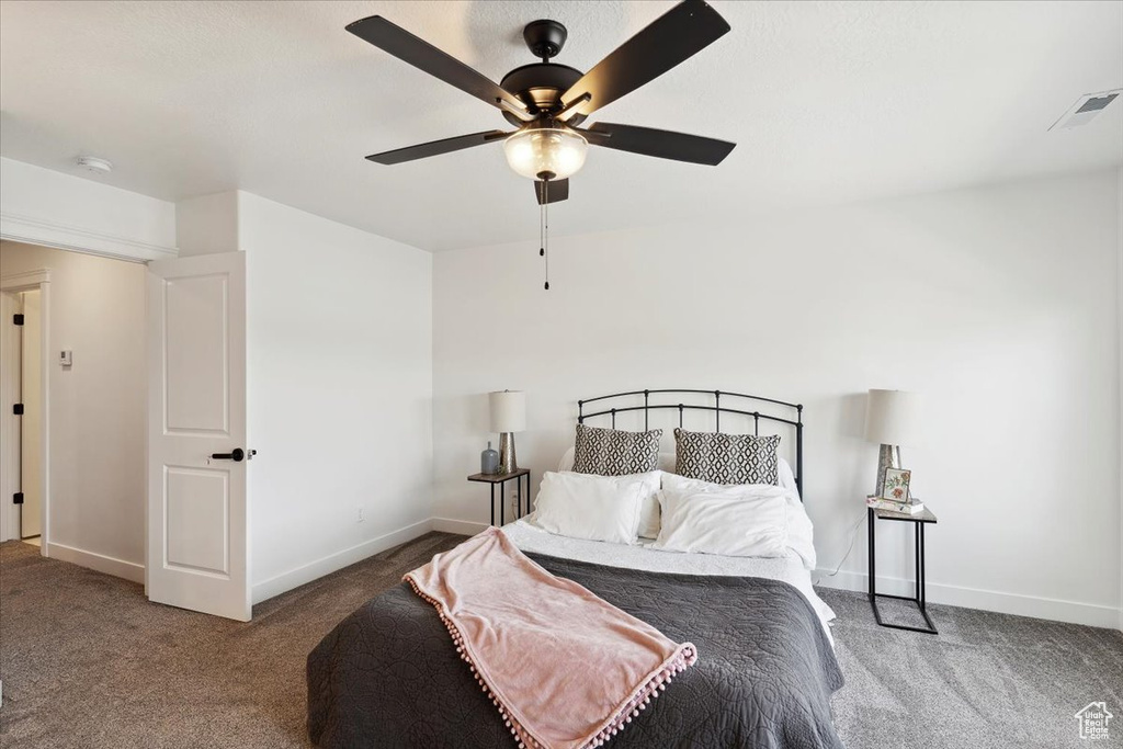 Carpeted bedroom featuring baseboards and ceiling fan