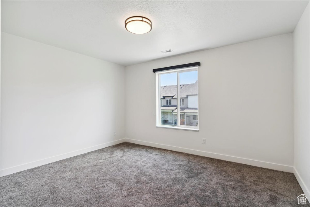 Carpeted empty room featuring baseboards