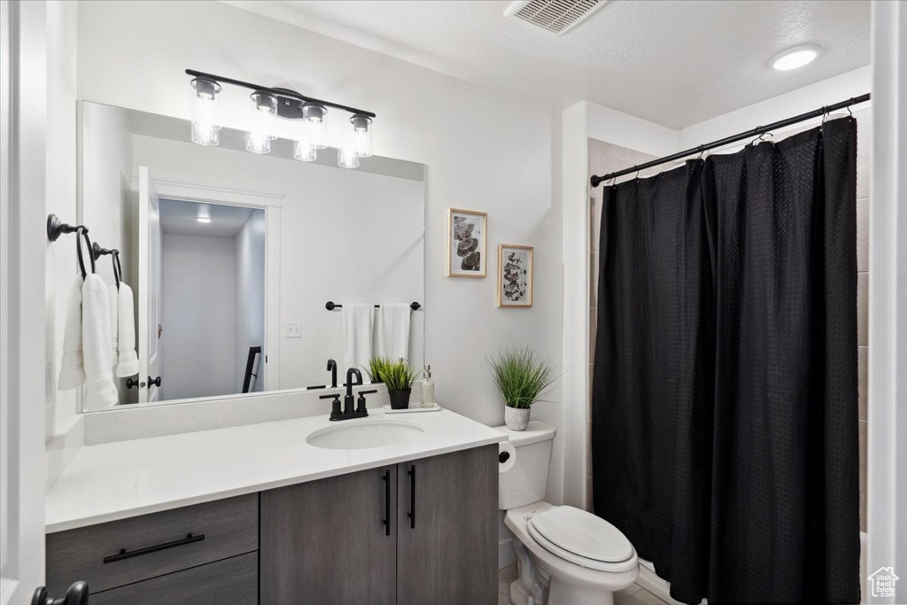 Bathroom with vanity, toilet, and a shower with curtain