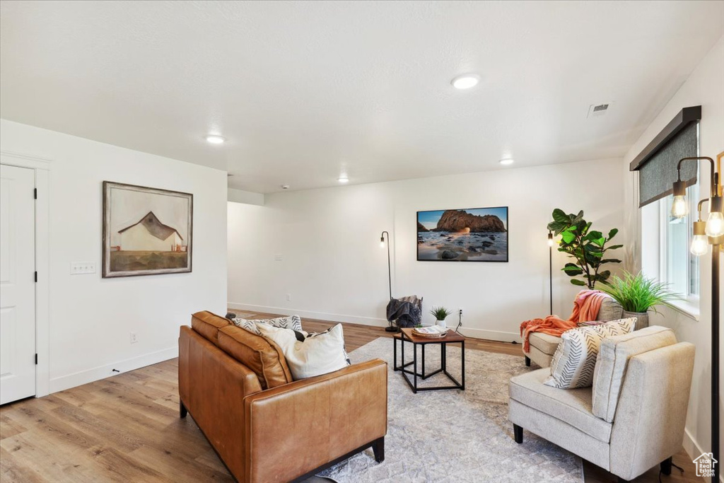 Living area featuring wood finished floors, baseboards, and recessed lighting