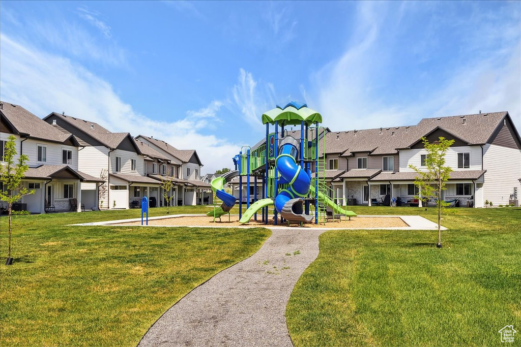 Community jungle gym with a residential view and a lawn
