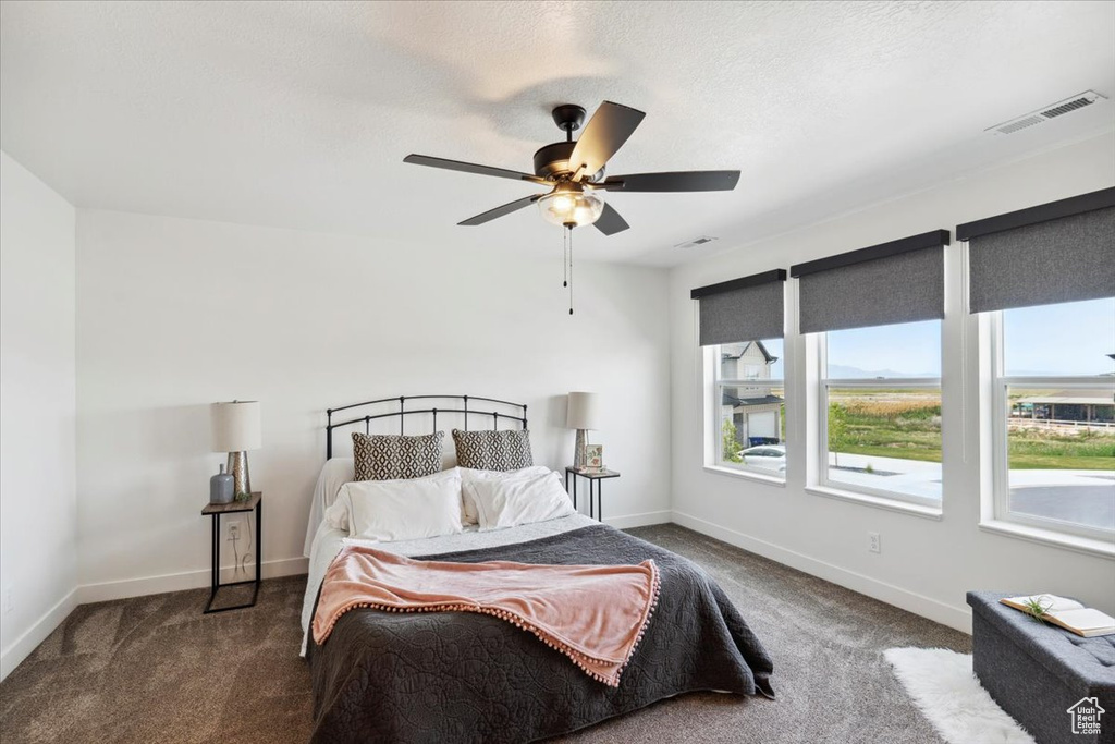 Bedroom with carpet flooring, baseboards, and ceiling fan