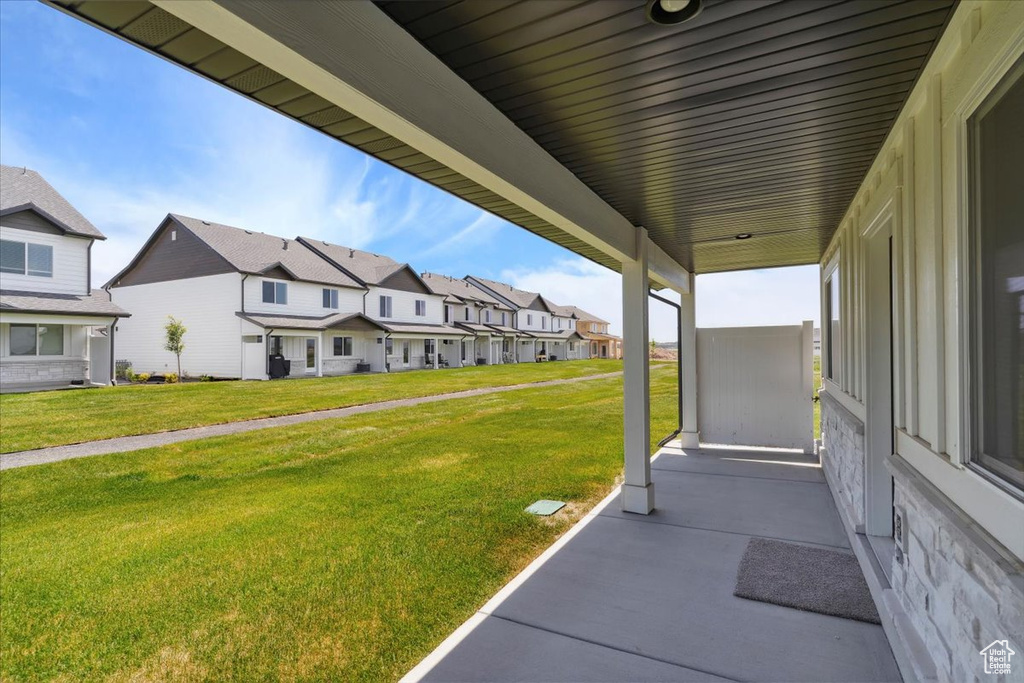 View of grassy yard featuring a residential view and a porch