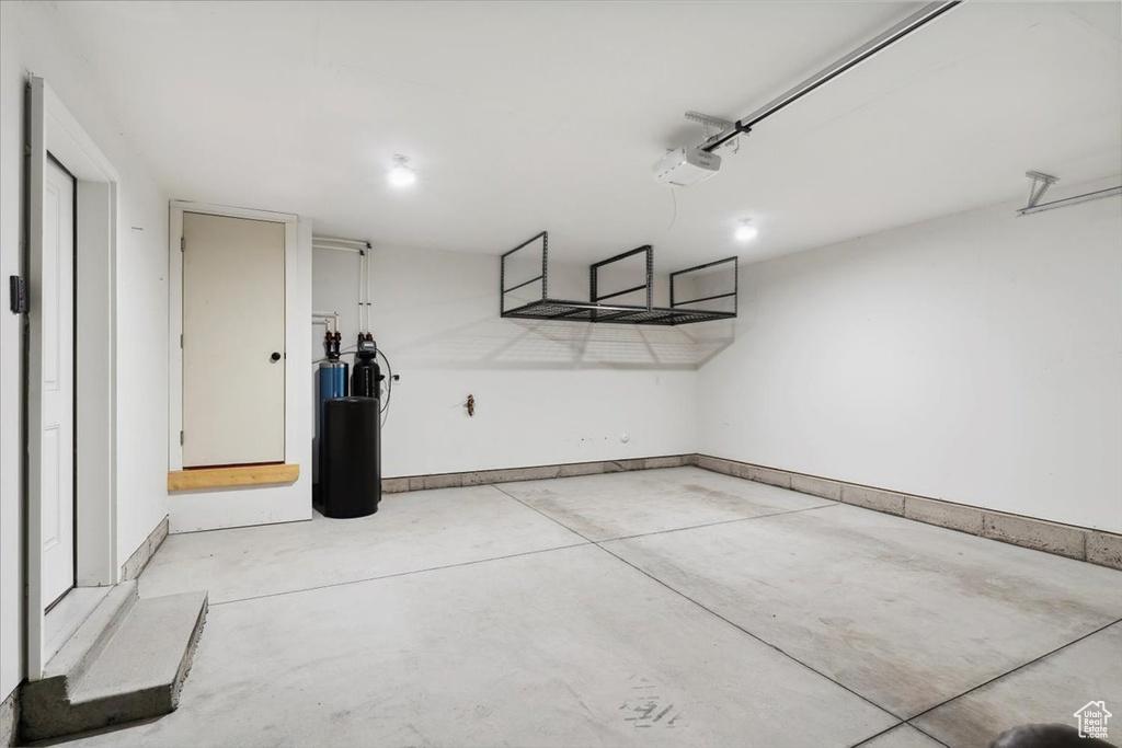 Garage with a garage door opener and baseboards