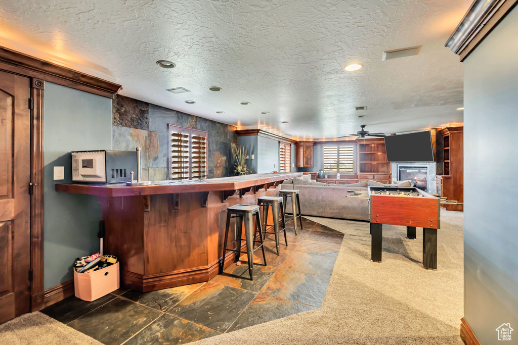 Indoor dry bar featuring ceiling fan, a textured ceiling, recessed lighting, and baseboards