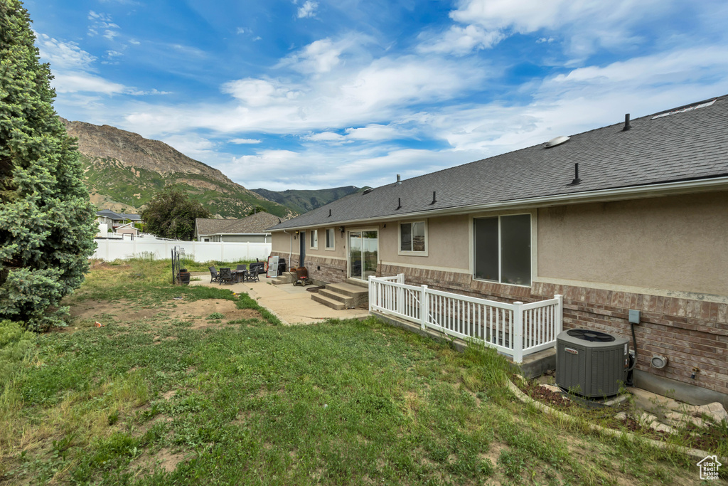 View of yard featuring central air condition unit, a patio, a mountain view, and entry steps