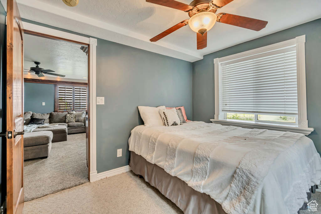 Carpeted bedroom featuring baseboards and a ceiling fan