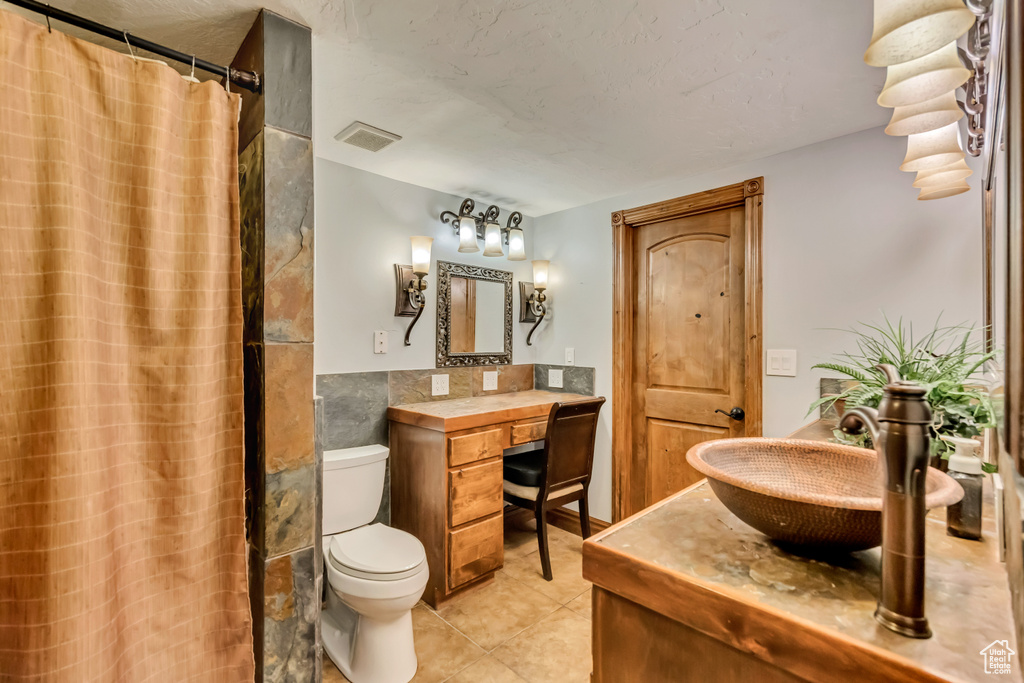 Full bathroom with vanity, toilet, tile patterned floors, and a shower with curtain