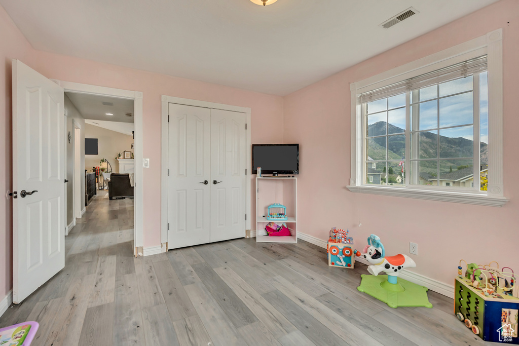 Recreation room featuring baseboards and light wood-type flooring