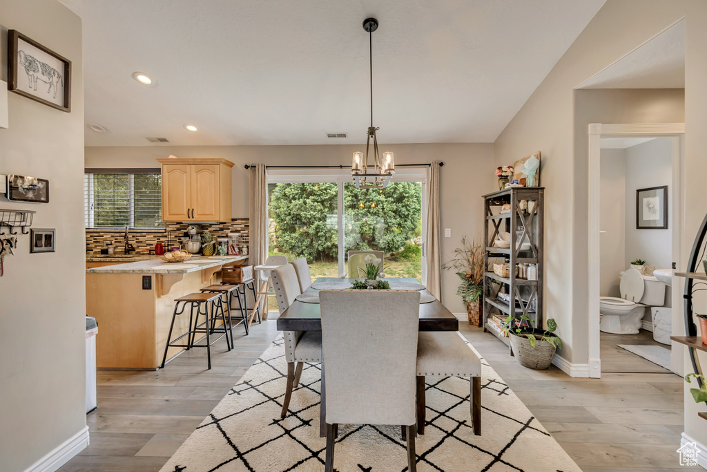 Dining area with light wood-style flooring, a chandelier, recessed lighting, and baseboards