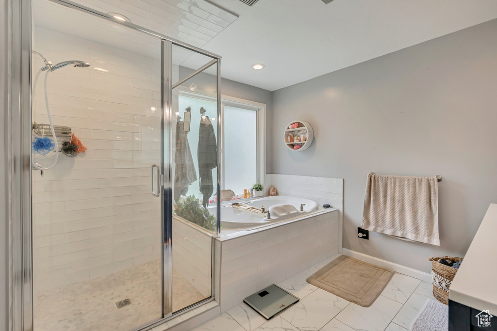 Bathroom with a bath, a stall shower, marble look tile flooring, and recessed lighting