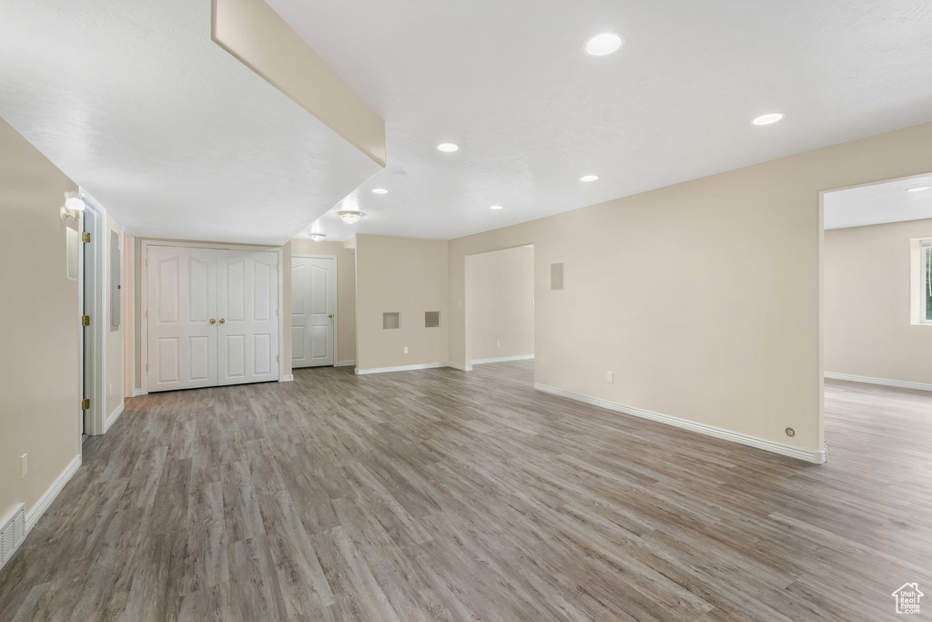 Unfurnished living room with light wood-style flooring, baseboards, and recessed lighting