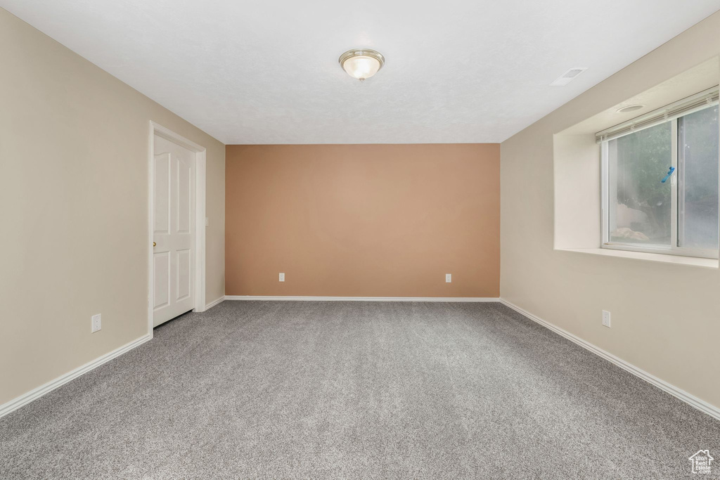 Carpeted spare room with baseboards