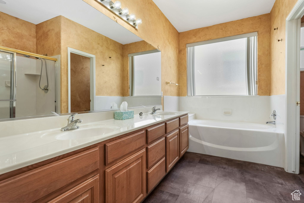 Full bathroom with a garden tub, double vanity, and a stall shower