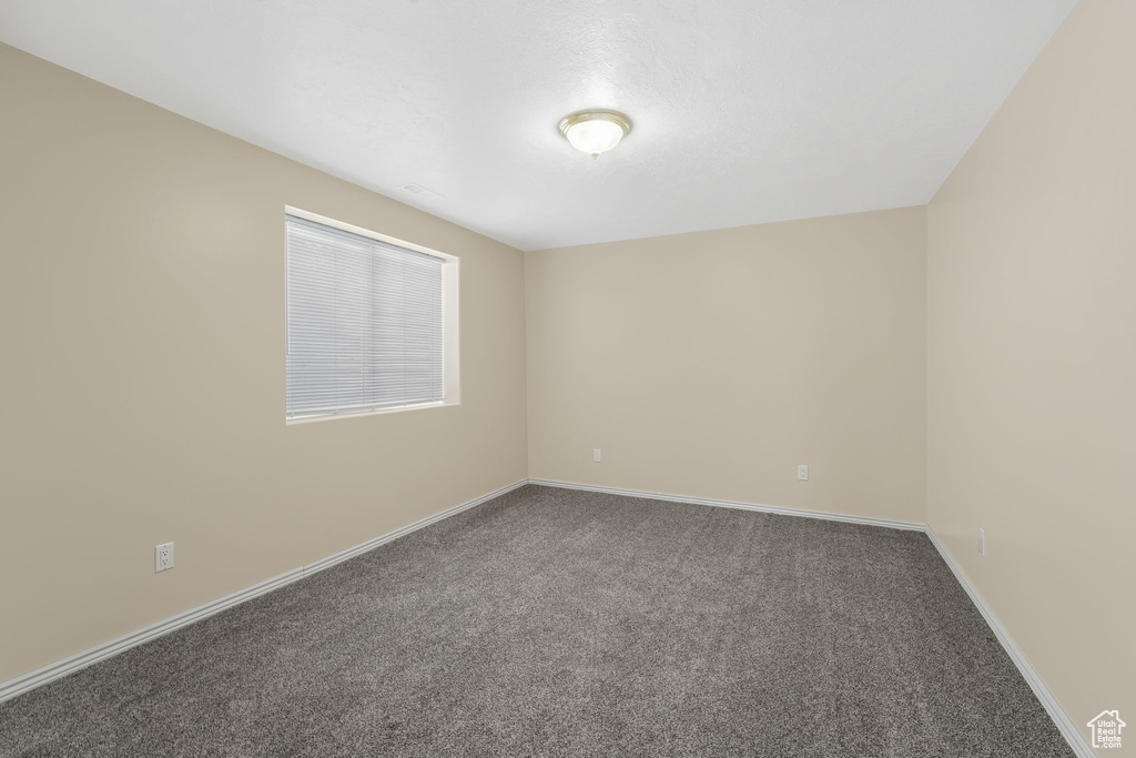 Carpeted spare room with baseboards