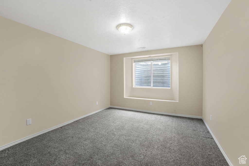 Carpeted spare room with baseboards