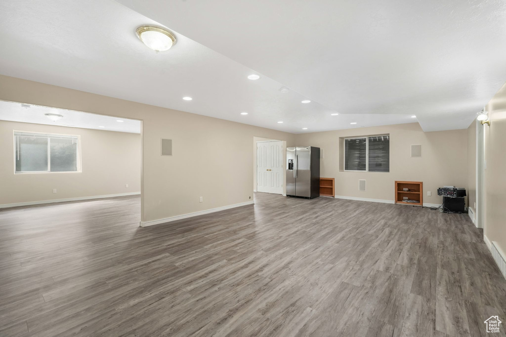 Unfurnished living room featuring wood finished floors, recessed lighting, and baseboards