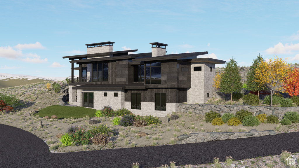 Rear view of house with a balcony, stone siding, and a chimney