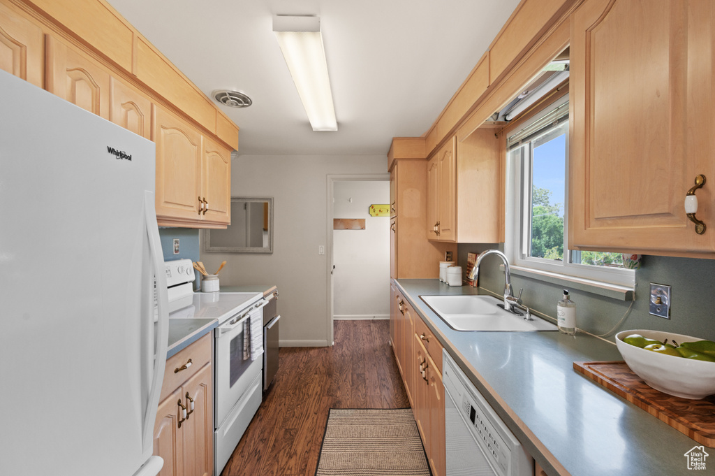 Kitchen featuring white appliances, a sink, and light brown cabinetry