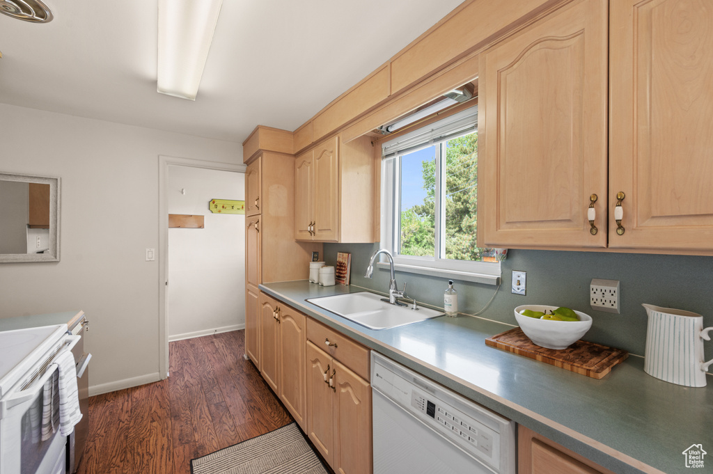 Kitchen with white appliances, a sink, dark wood-style flooring, light brown cabinets, and baseboards