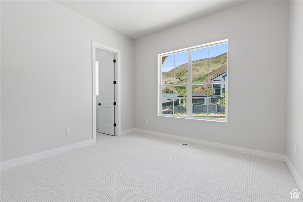 Unfurnished room featuring carpet floors and baseboards