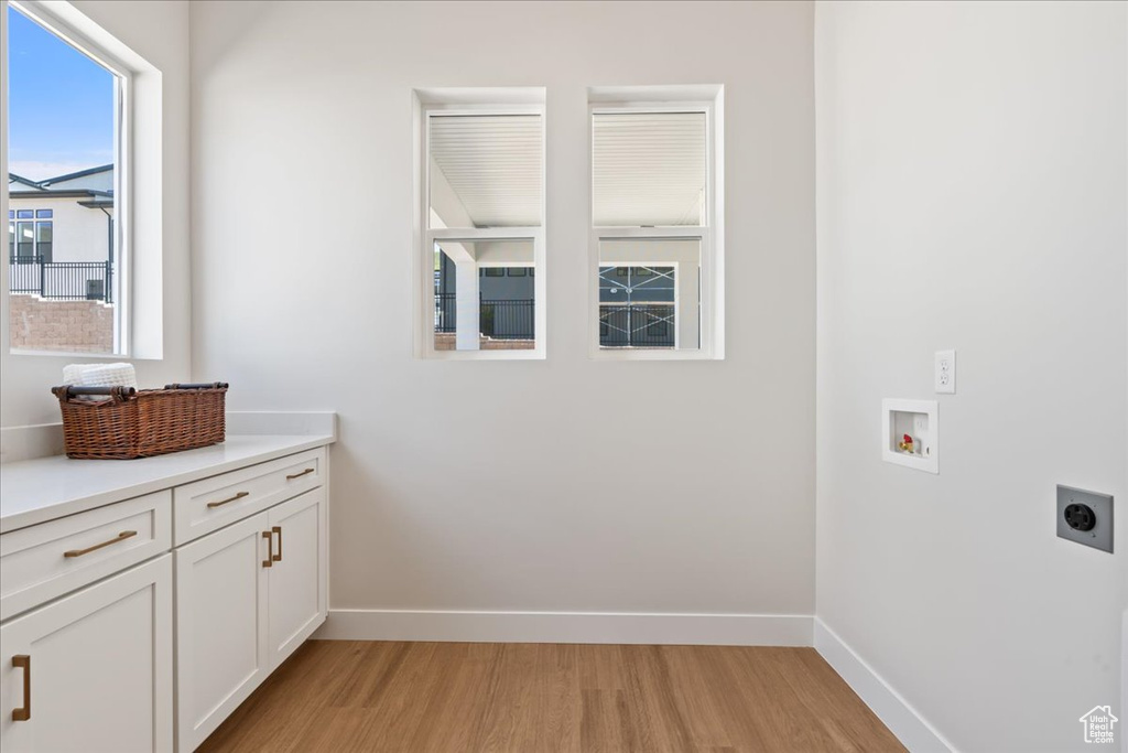 Laundry room with electric dryer hookup, light wood finished floors, washer hookup, and baseboards