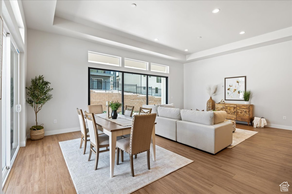 Dining area featuring a raised ceiling, recessed lighting, wood finished floors, and baseboards