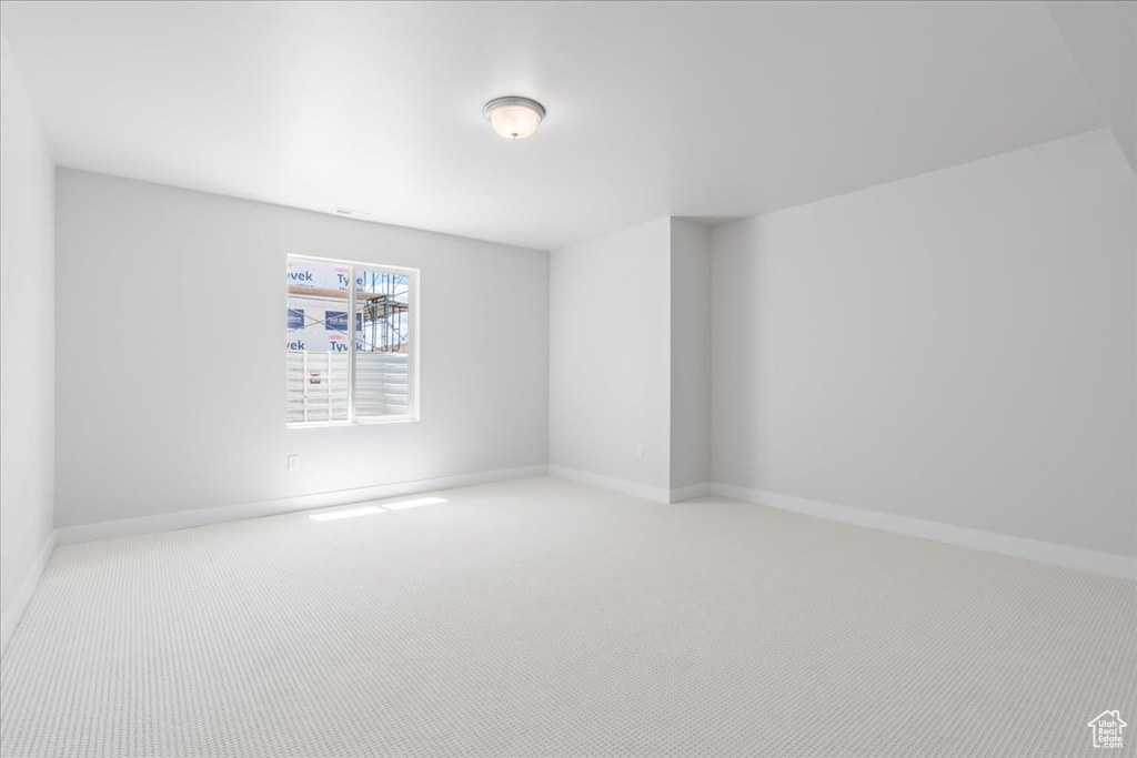 Carpeted empty room with baseboards