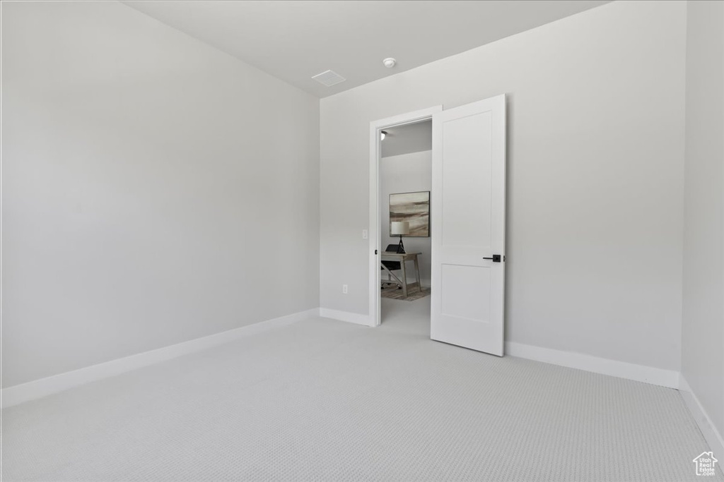 Empty room with light carpet and baseboards