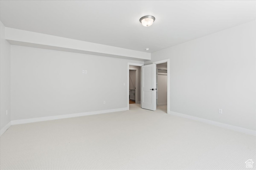 Unfurnished bedroom with light carpet, baseboards, and a closet