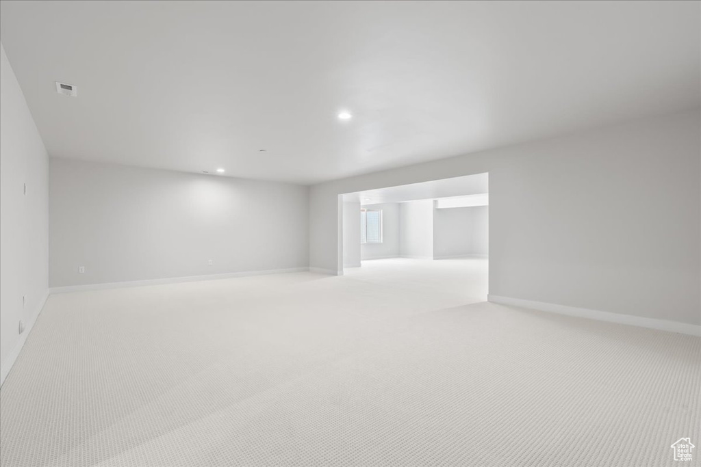 Empty room featuring recessed lighting, baseboards, and light colored carpet