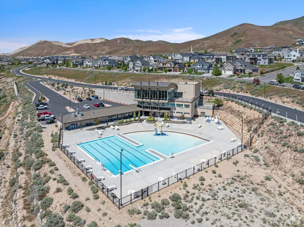 Aerial perspective of suburban area with a mountain backdrop and a pool area