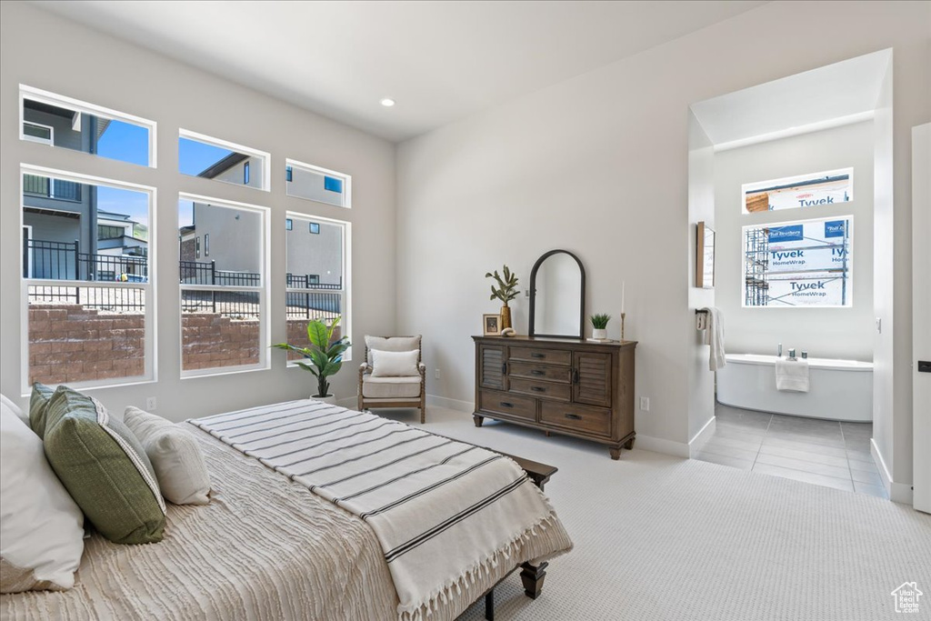 Tiled bedroom with baseboards, carpet, recessed lighting, and ensuite bathroom