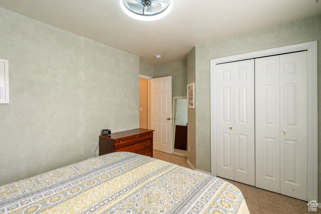 Bedroom featuring light carpet and a closet