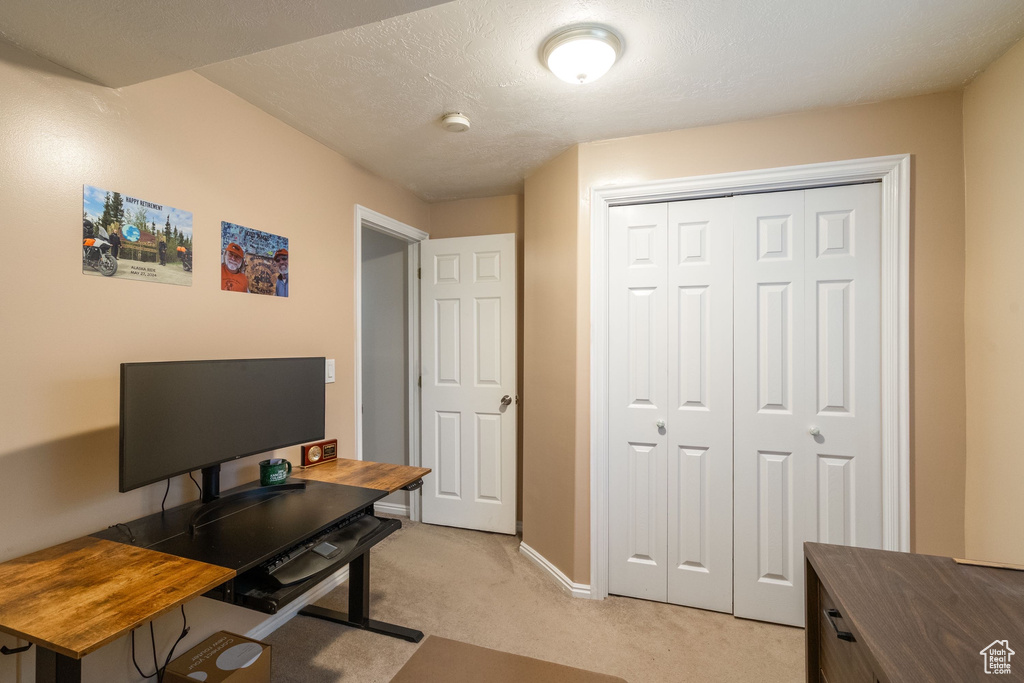 Home office featuring light carpet and baseboards