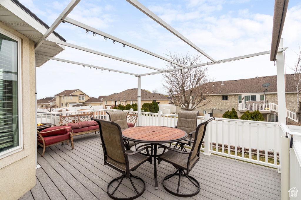 Wooden terrace featuring outdoor dining area and a residential view