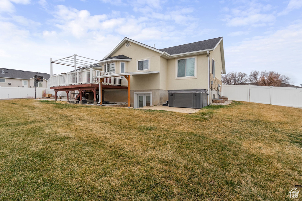 Rear view of property with a hot tub, a deck, stucco siding, french doors, and a patio area