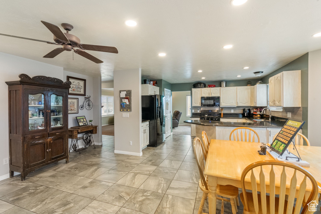 Kitchen with black appliances, a peninsula, a ceiling fan, baseboards, and recessed lighting