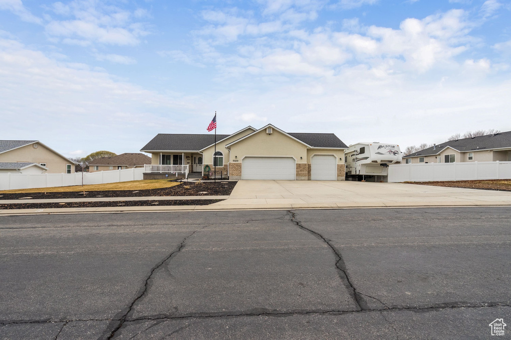 View of front of home featuring concrete driveway, an attached garage, stucco siding, and a porch