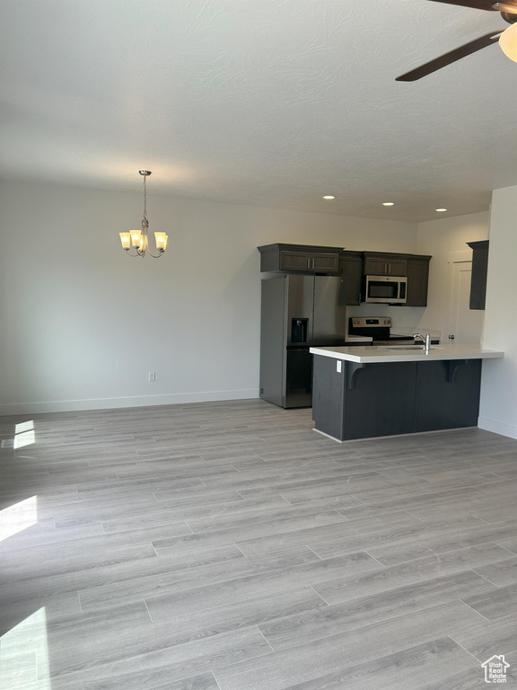 Kitchen featuring appliances with stainless steel finishes, a chandelier, baseboards, light countertops, and a ceiling fan