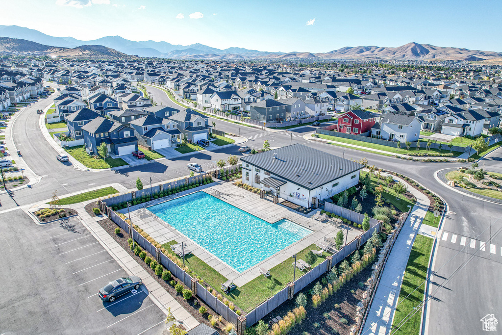 Aerial perspective of suburban area with a pool and a mountain backdrop