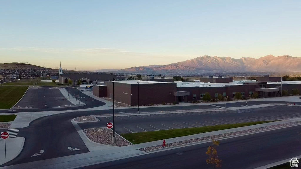 View of asphalt street featuring a mountain view, sidewalks, traffic signs, and curbs