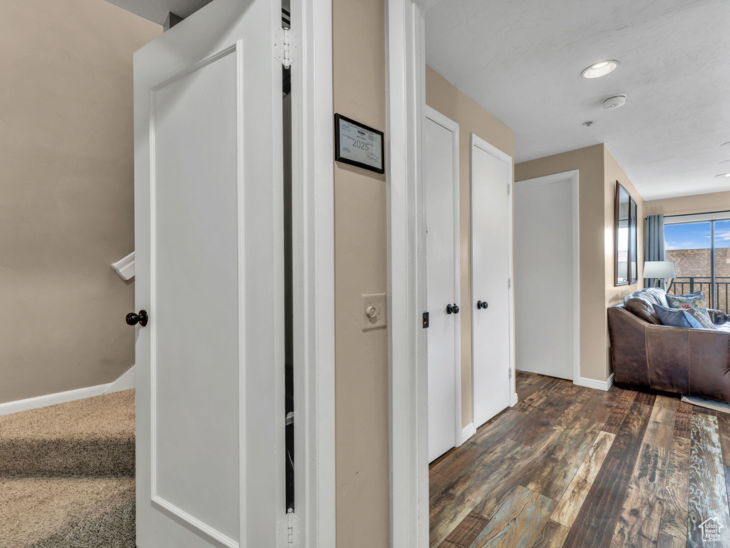 Hallway featuring dark wood finished floors and baseboards