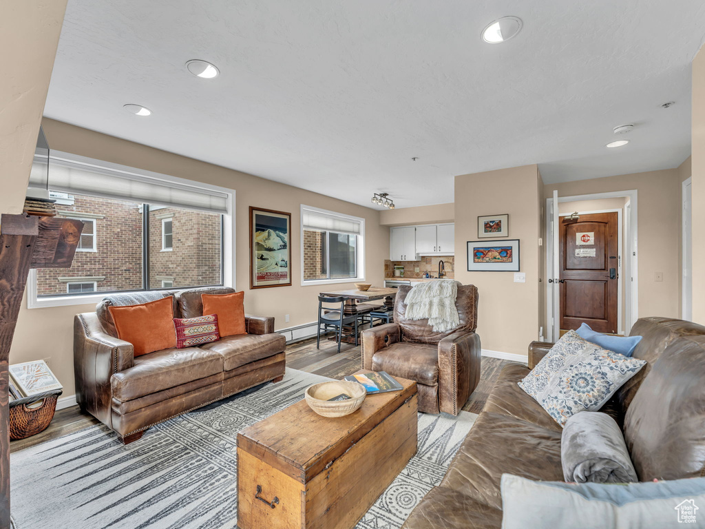 Living room with baseboards, healthy amount of natural light, a baseboard radiator, and recessed lighting