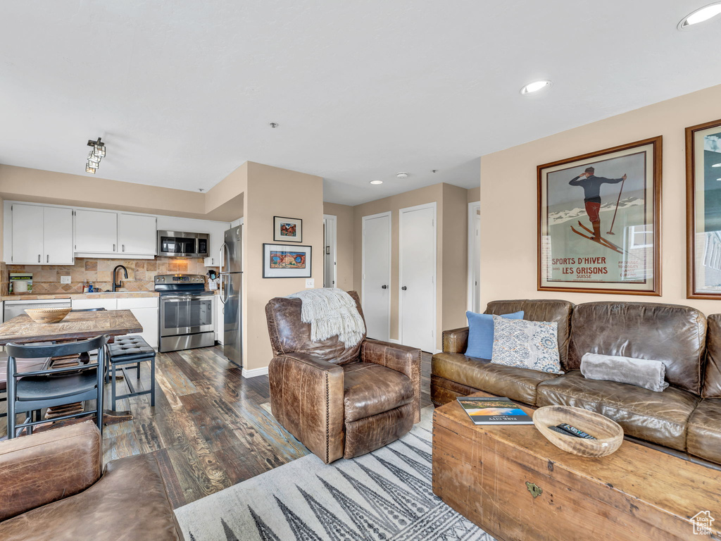 Living area featuring dark wood-style floors, recessed lighting, and baseboards